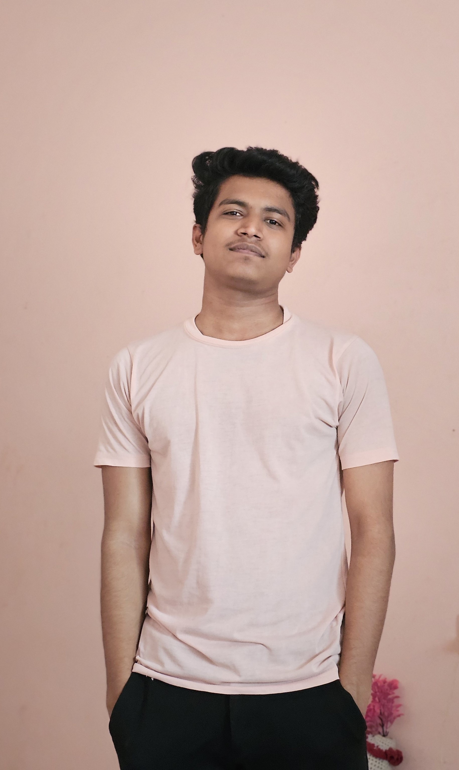 Prathamesh Kasar, portrait in a light T-shirt against a pink wall