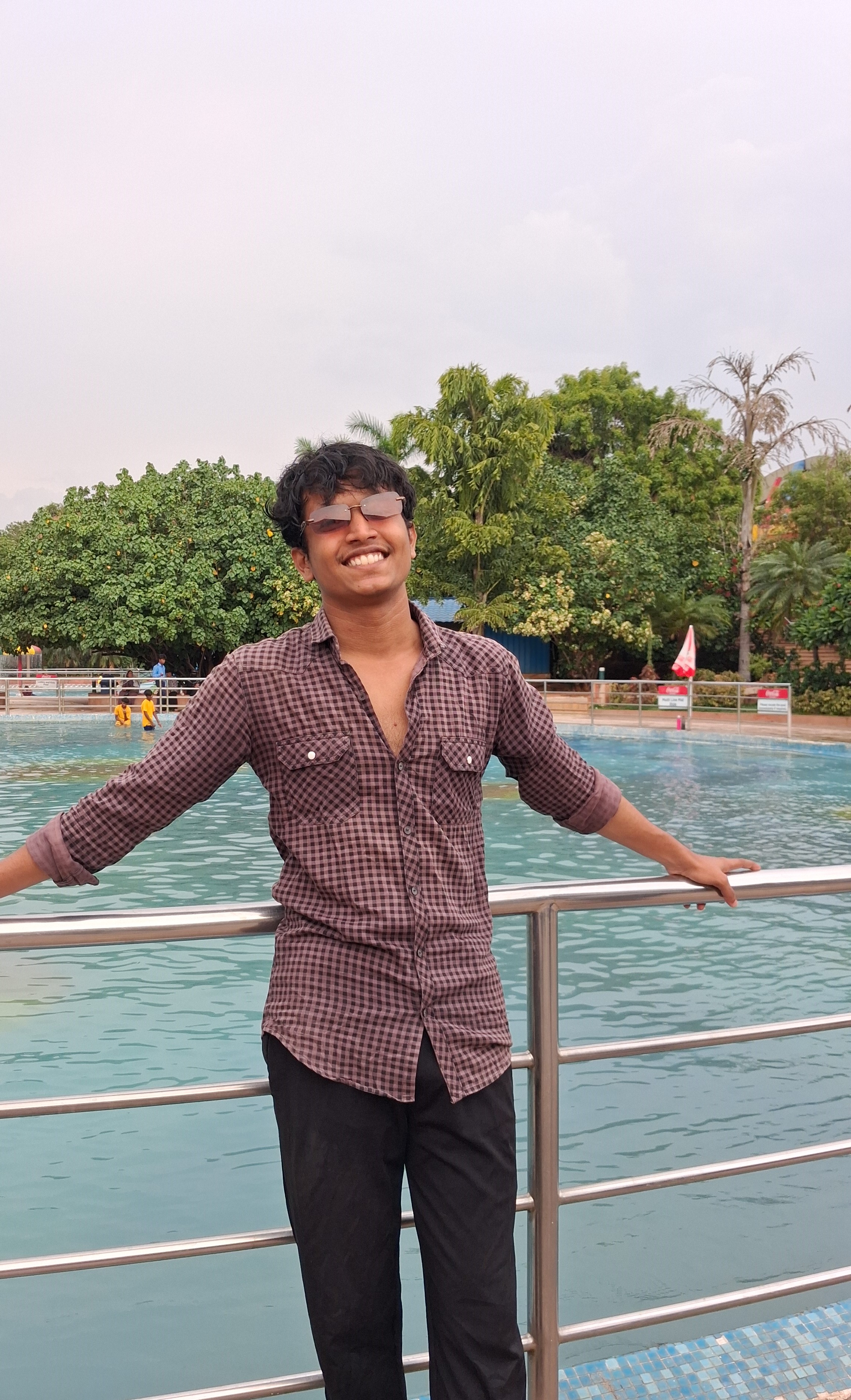 Prathamesh Kasar leaning on a railing by a pool
