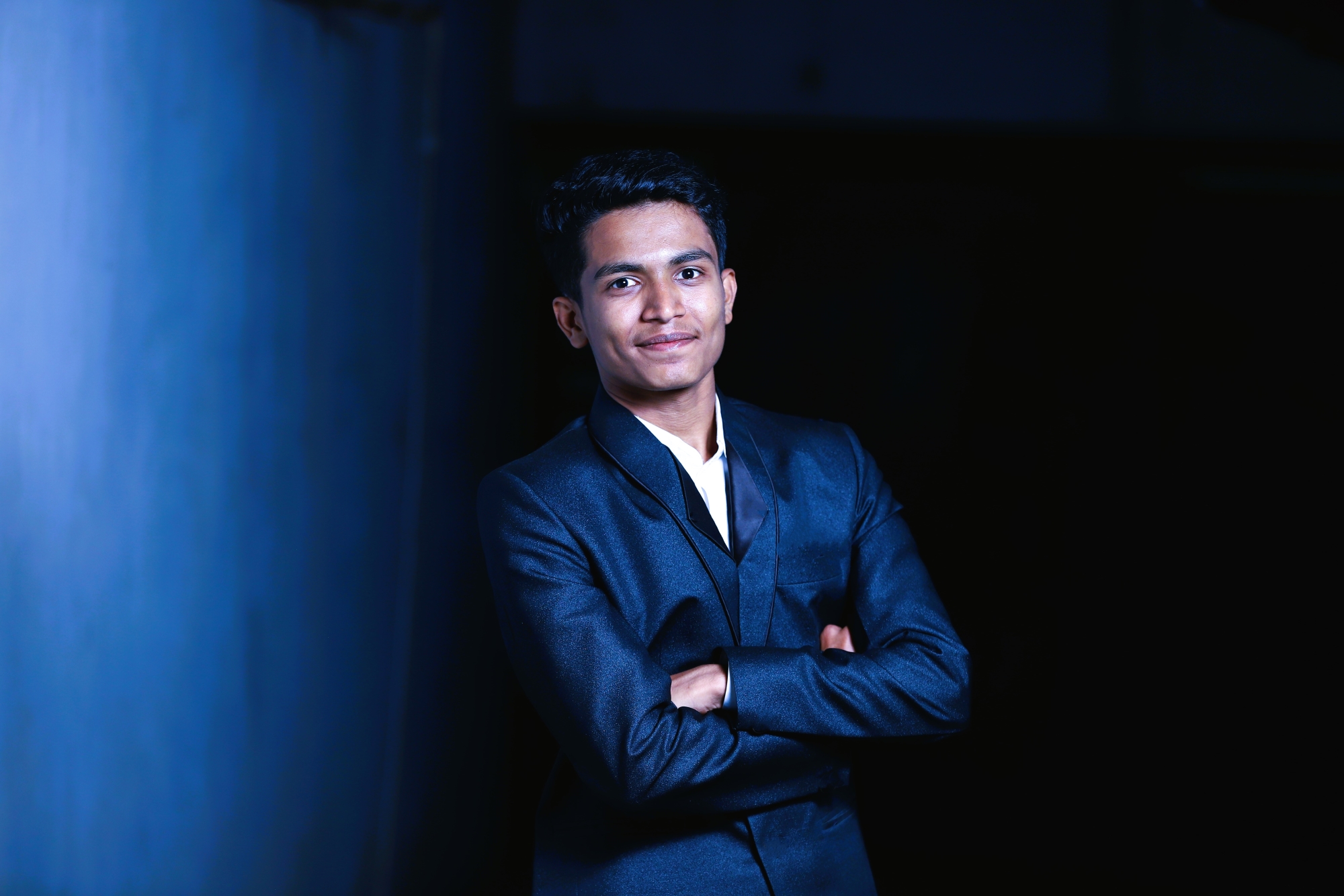 Prathamesh Kasar in a navy suit against a dark blue backdrop